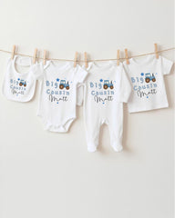 A collection of baby clothes, including onesies and bibs, hanging on a clothesline.