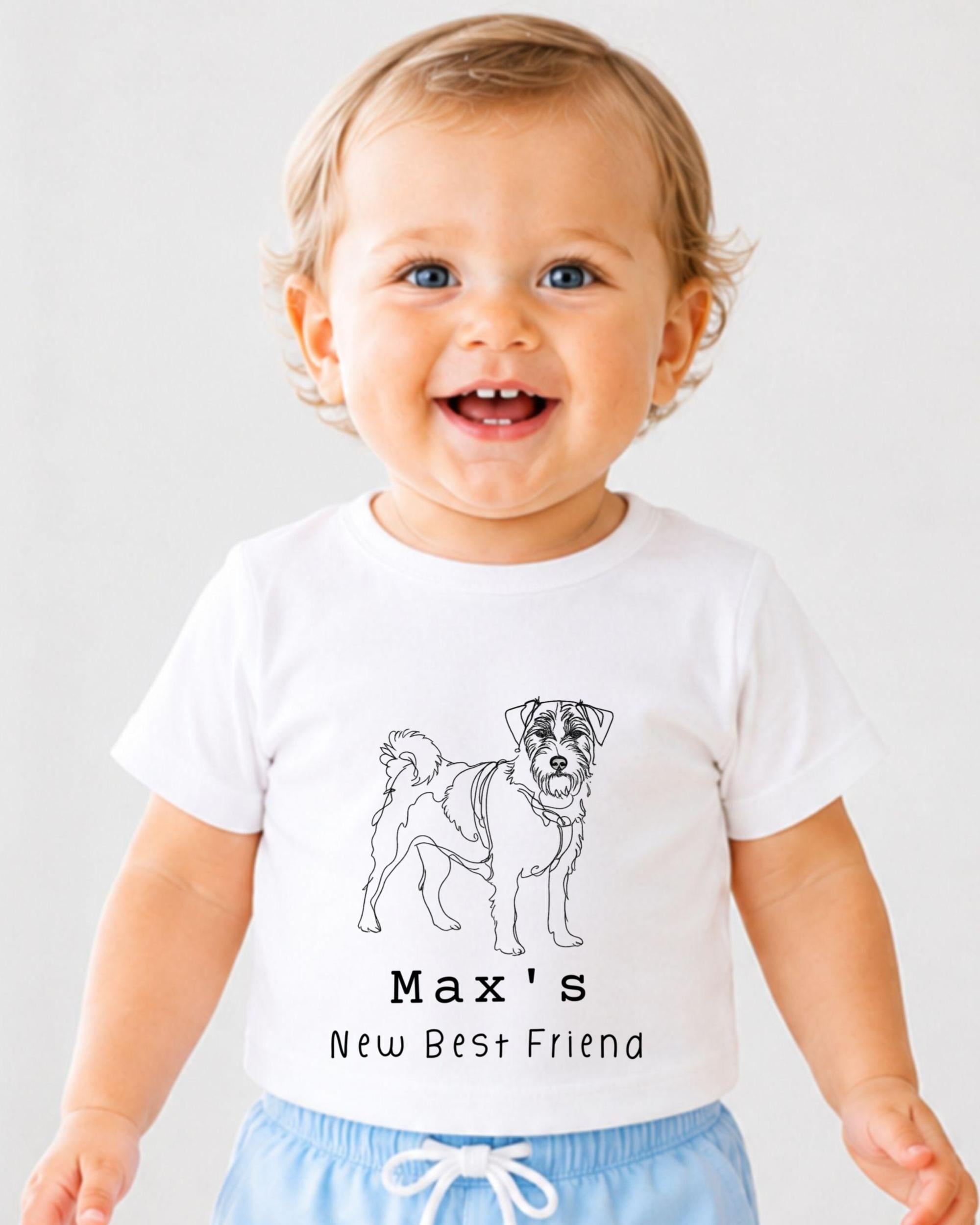 A smiling baby wearing a white t-shirt with a black and white illustration of a dog and the text "Max's New Best Friend".