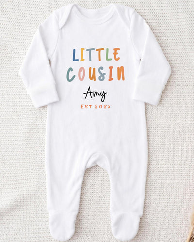 A white bodysuit with the text "LITTLE COUSIN Amy EST 202x" printed on it.