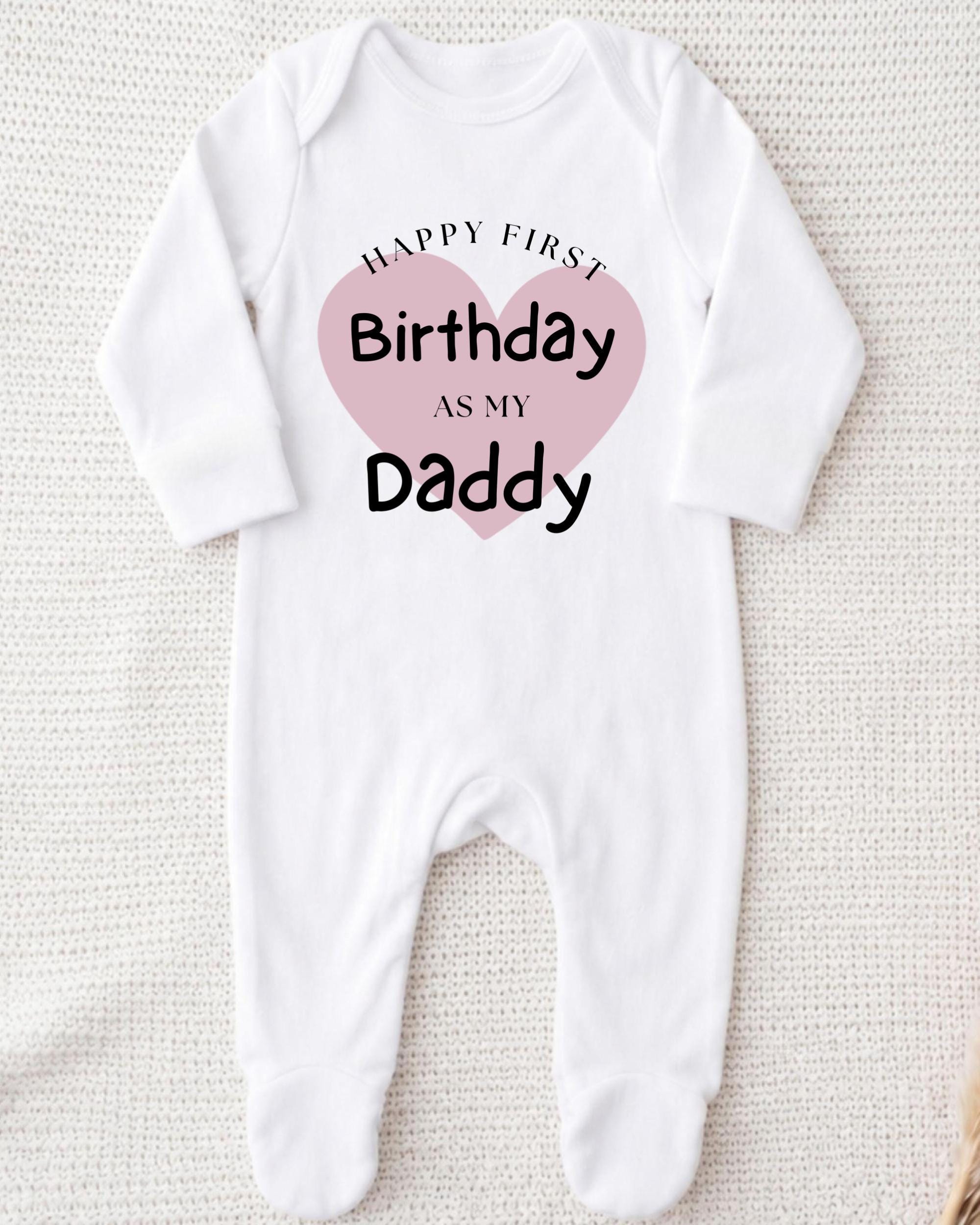 A white onesie with a pink heart and text that reads "Happy first Birthday as my Daddy".