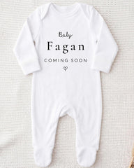 A white onesie with the text "Baby Fagan Coming Soon" printed on it.