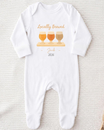 A white onesie with a graphic design of three beer glasses and the text "Locally Brewed Jack 2026" printed on it.