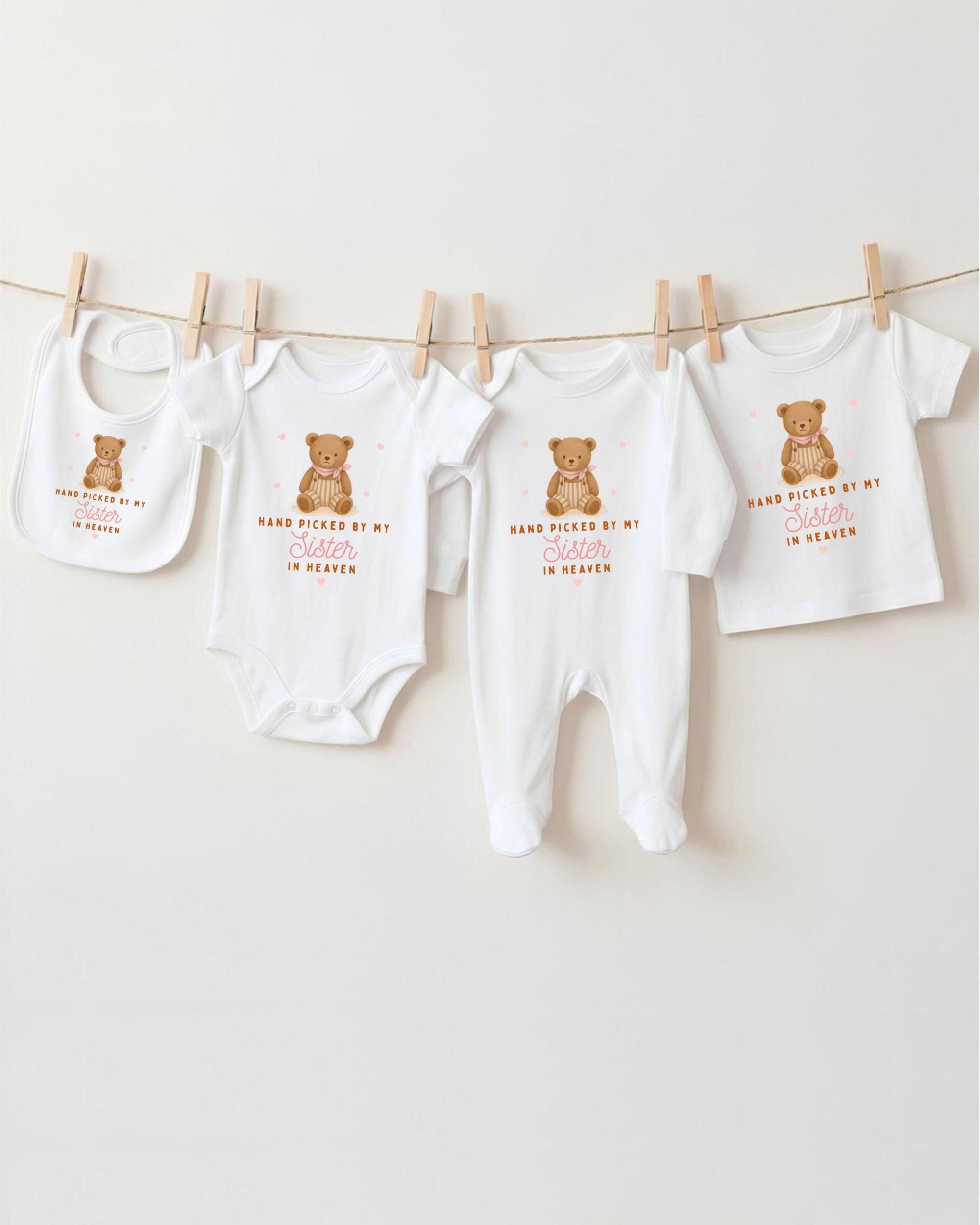 A collection of baby clothes, including onesies and bibs, hanging on a clothesline.