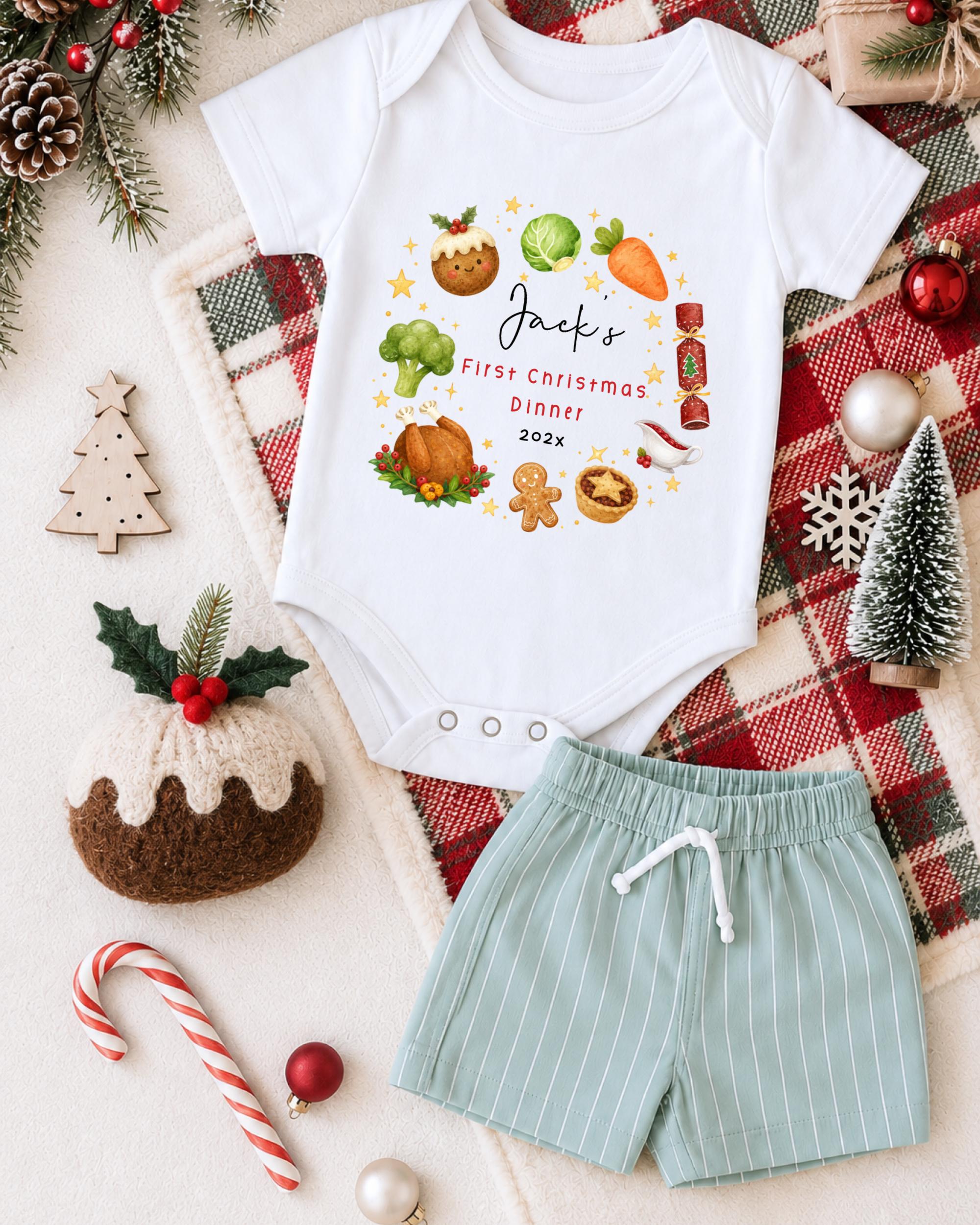 A white onesie with a Christmas-themed design, a pair of green shorts, and various Christmas decorations such as a pine cone, a snowflake, and a small Christmas tree.