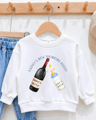 A white sweatshirt with a graphic design depicting a wine bottle and a baby bottle, along with the text "DADMY'S NEW DRINKING BUDDY" printed on it.