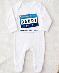 A white onesie with a graphic design on it, featuring the text "Cheering for my DADDY" and "MARCHON NAME HERE" along with a custom date field.