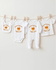 a collection of baby clothes hanging on a clothesline, with each piece featuring a coffee cup design.