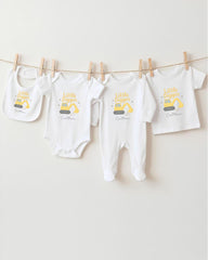A collection of baby clothes, including onesies and pants, hanging on a clothesline.