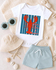 A white baby onesie with a red lobster design, a beige bucket hat, and a pair of light blue shorts, along with some sunglasses and seashells, are arranged on a beige surface.