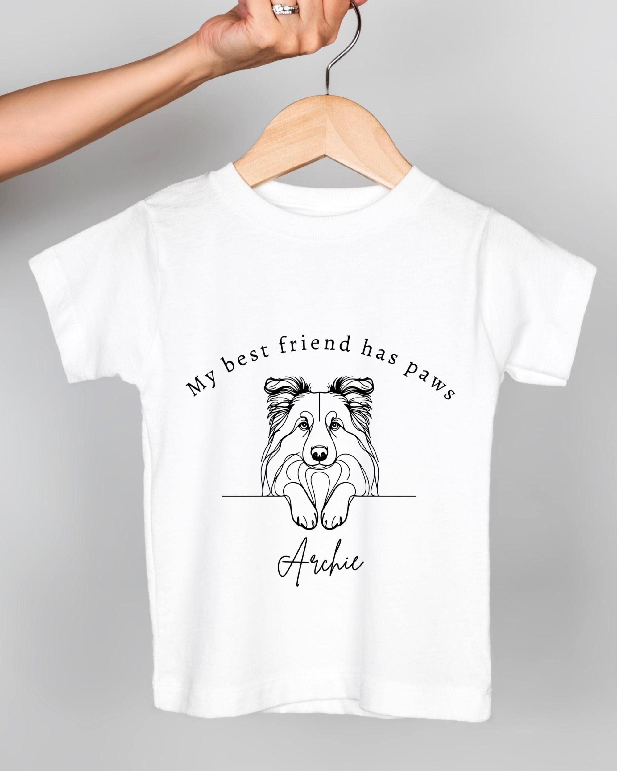 A white t-shirt with a graphic design of a dog's head and the text "My best friend has paws" printed on it.