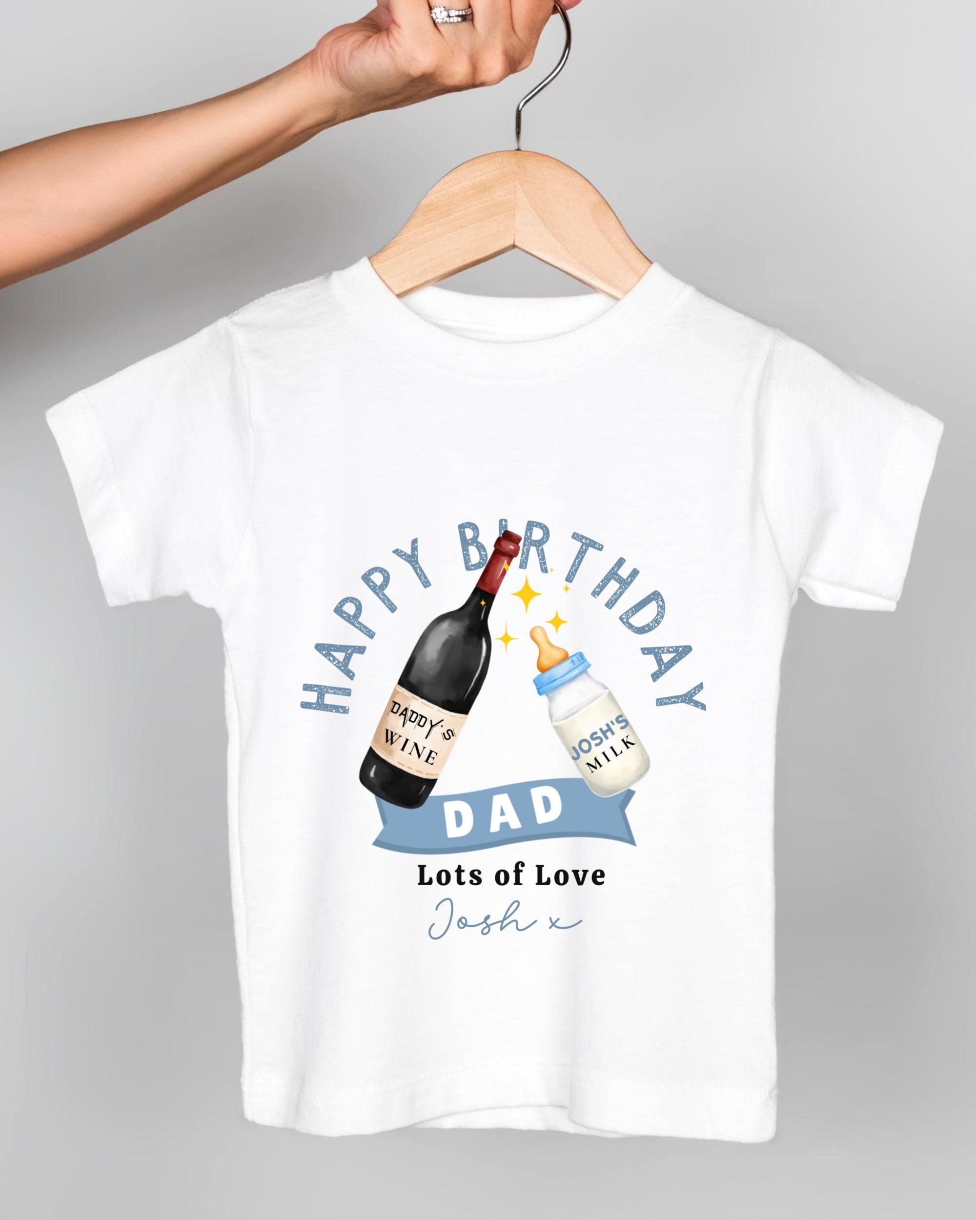 A white t-shirt with a graphic design featuring a bottle of wine and a baby bottle, along with the text "Happy Birthday Dad Lots of Love Josh x".