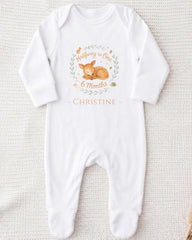 A white onesie with a graphic of a baby deer and text that reads "Halfway to One 6 Months - Christine".