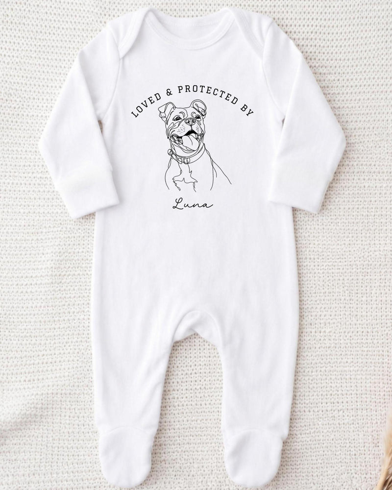 A white bodysuit with a black and white illustration of a dog and the text "LOVED & PROTECTED BY" printed on it.