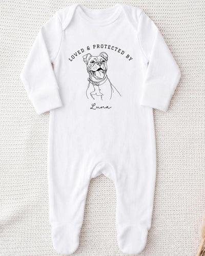 A white bodysuit with a black and white illustration of a dog and the text "LOVED & PROTECTED BY" printed on it.