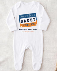 A white onesie with a graphic design on it, featuring the text "Cheering for my DADDY" and "MARCHON NAME HERE" along with a custom name.