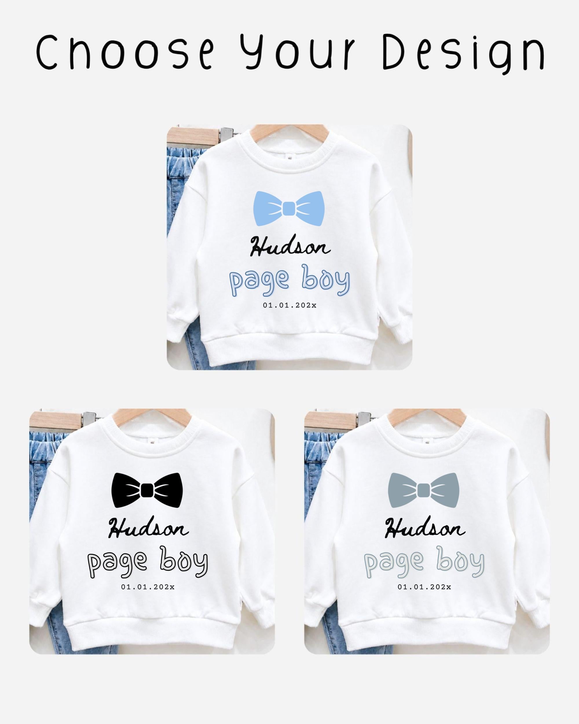 three white sweatshirts with the name "Hudson" and the date "01.01.2023" printed on them. The sweatshirts are arranged on hangers, suggesting they are for sale or display.