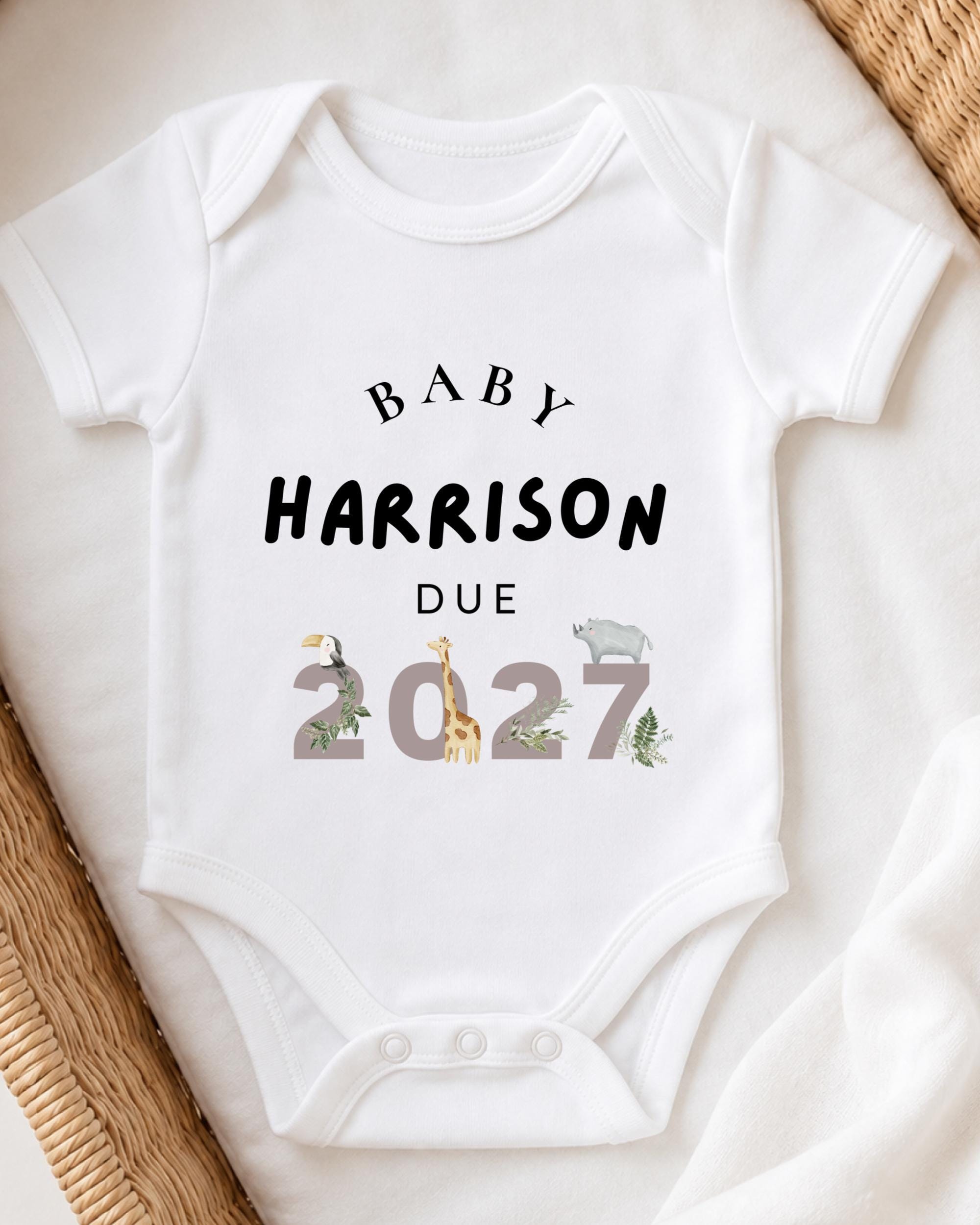 A white baby onesie with text and illustrations printed on it.