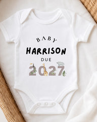 A white baby onesie with text and illustrations printed on it.