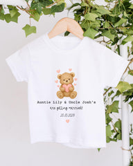 A white t-shirt with a graphic of a teddy bear holding a heart and the text "Auntie Lily & Uncle Josh's are getting married! 20.10.2029" printed on it.
