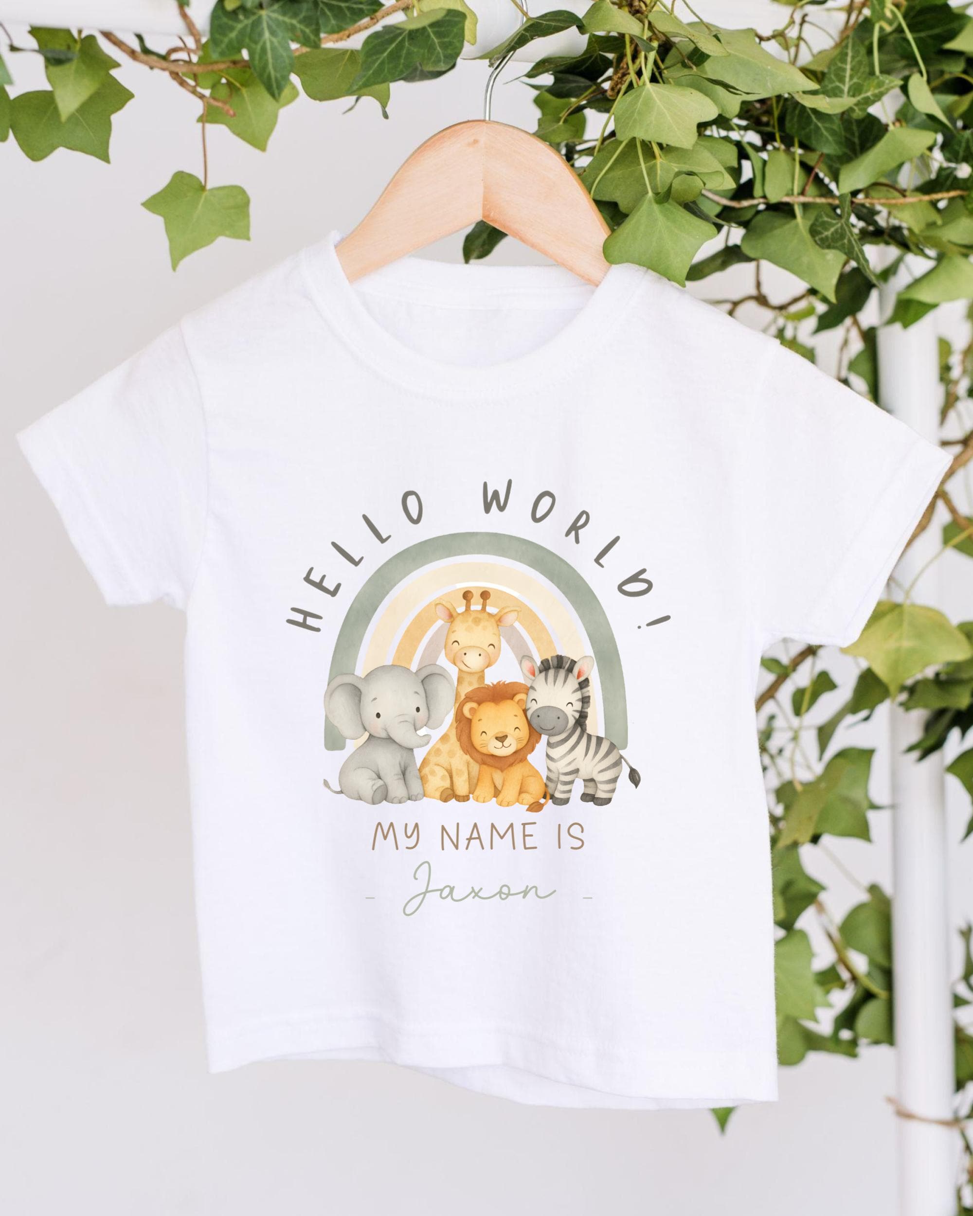 A white t-shirt with a graphic design featuring a rainbow and various animals, including an elephant, lion, and zebra, along with the text "Hello World!" and "My Name Is" written below.