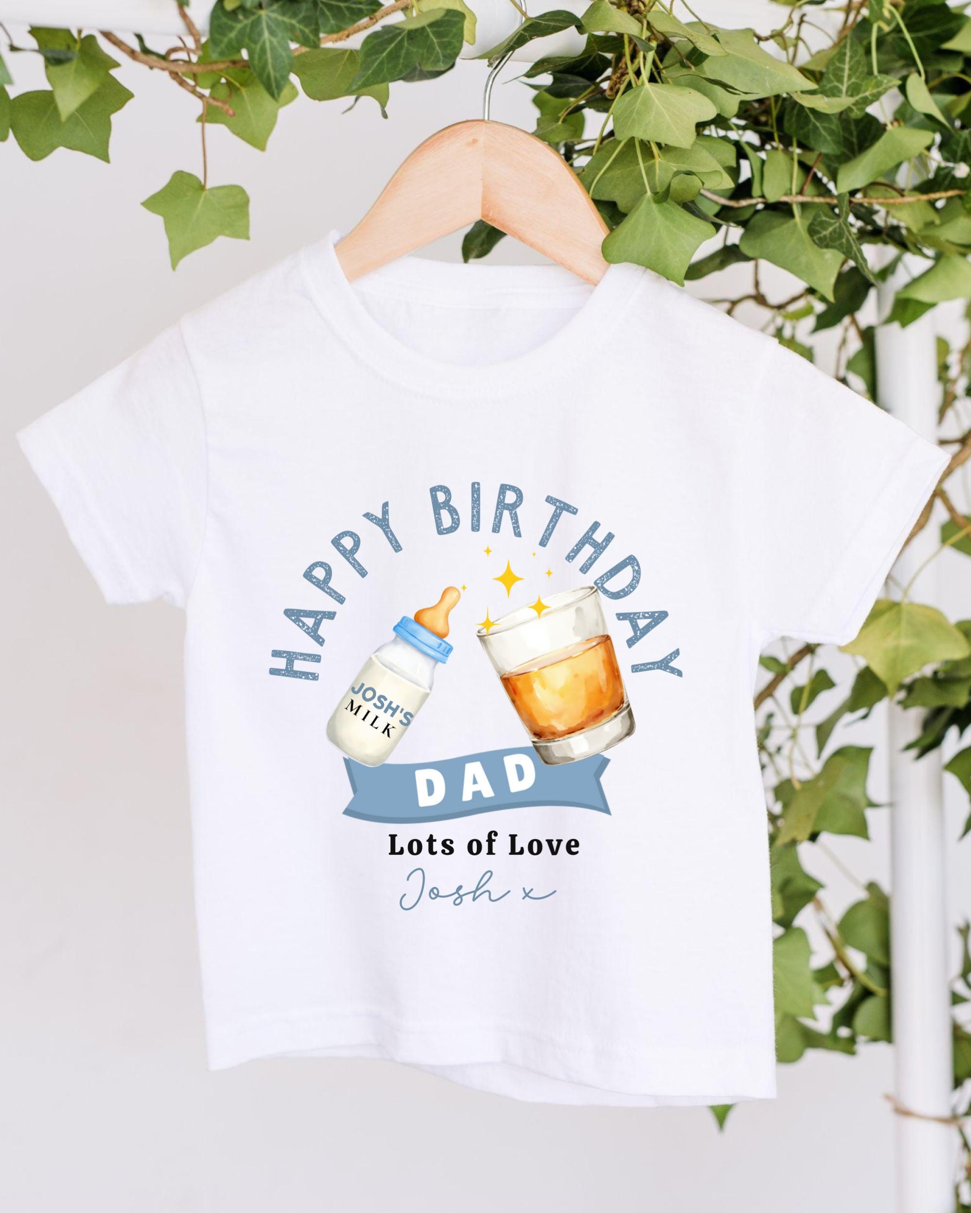 A white t-shirt with a graphic design that says "Happy Birthday Dad" and includes a bottle of milk and a glass of beer.