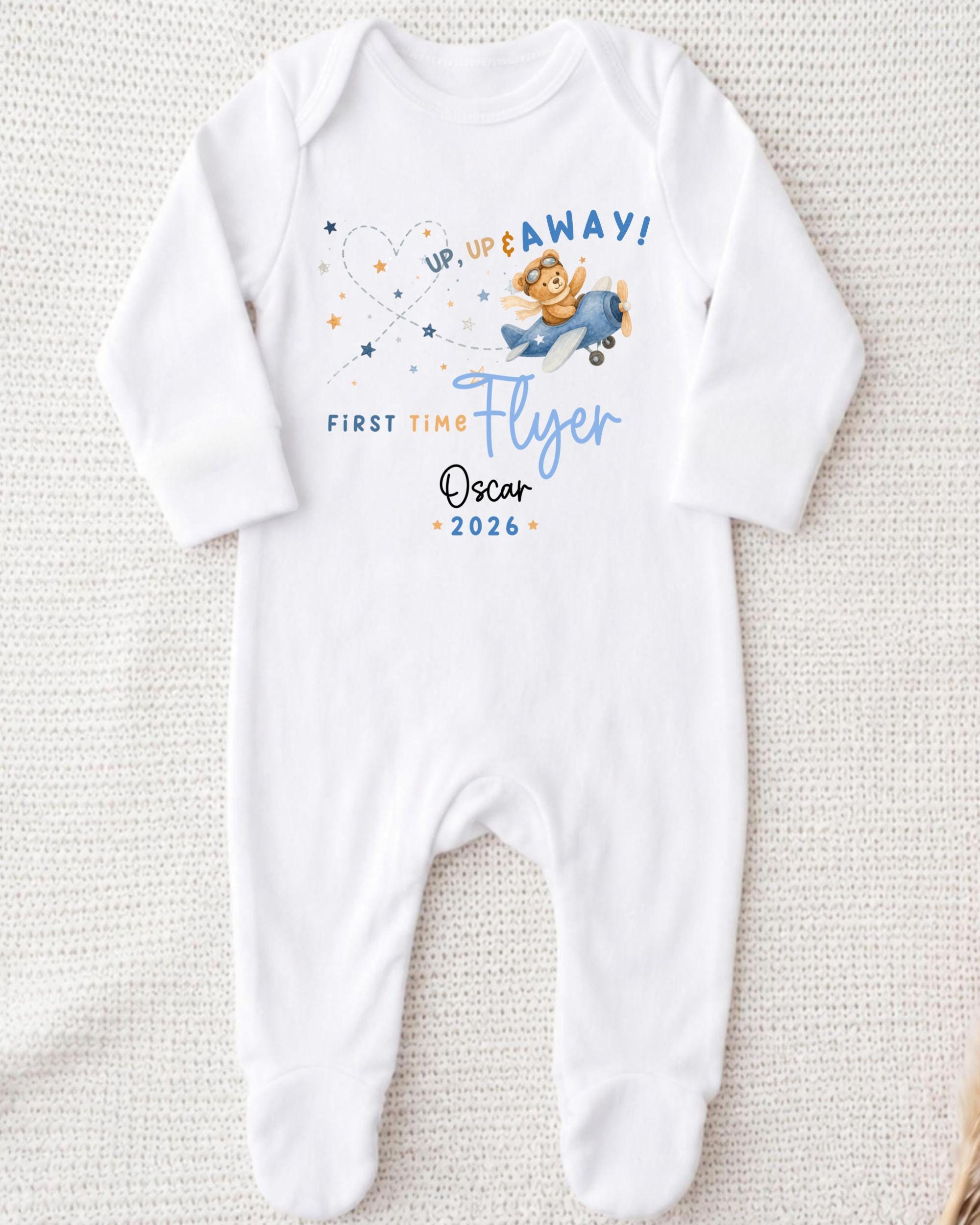 A white onesie with a cartoon airplane and text printed on it.