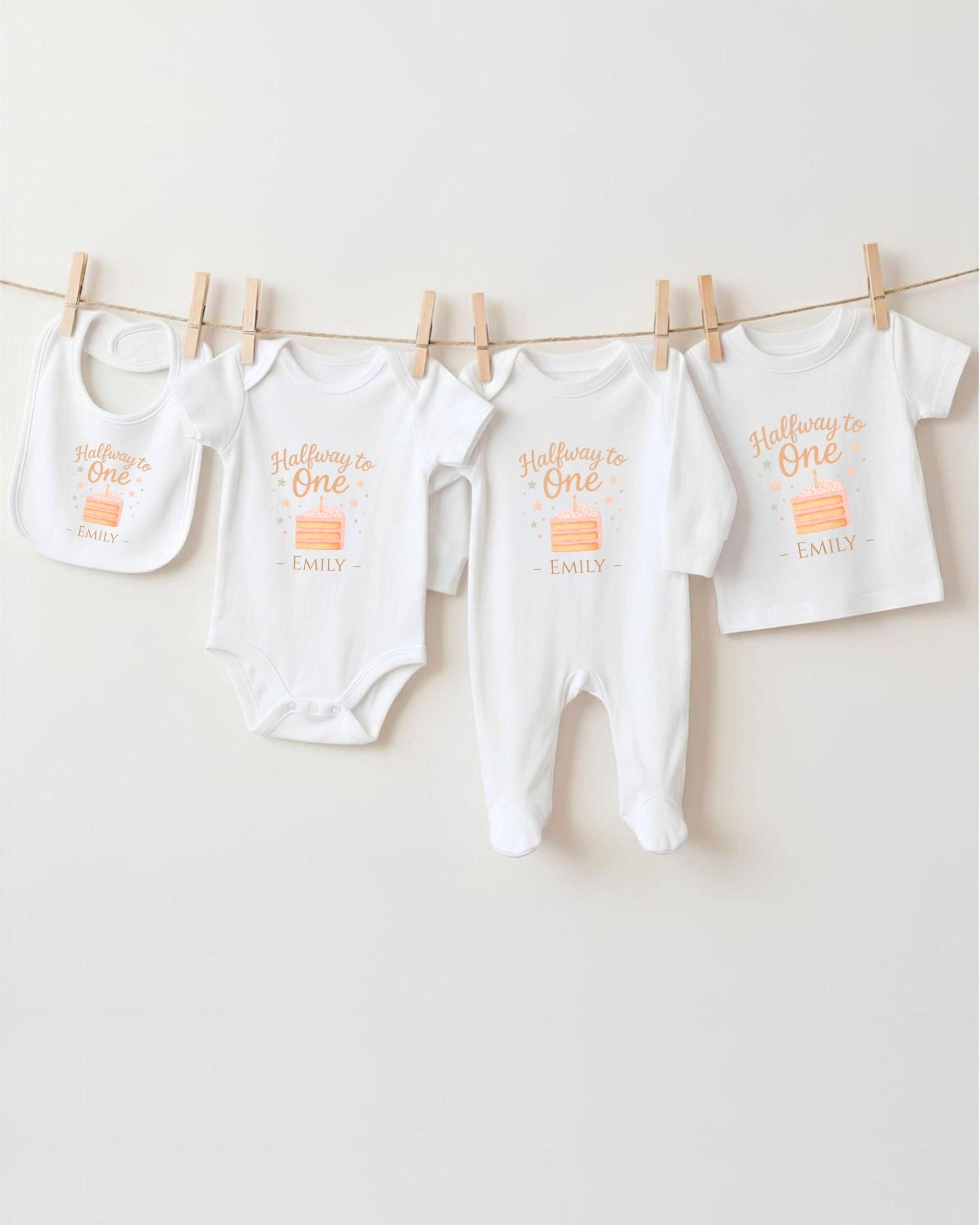 A row of four white baby clothes, including onesies and pajamas, hanging on a clothesline.