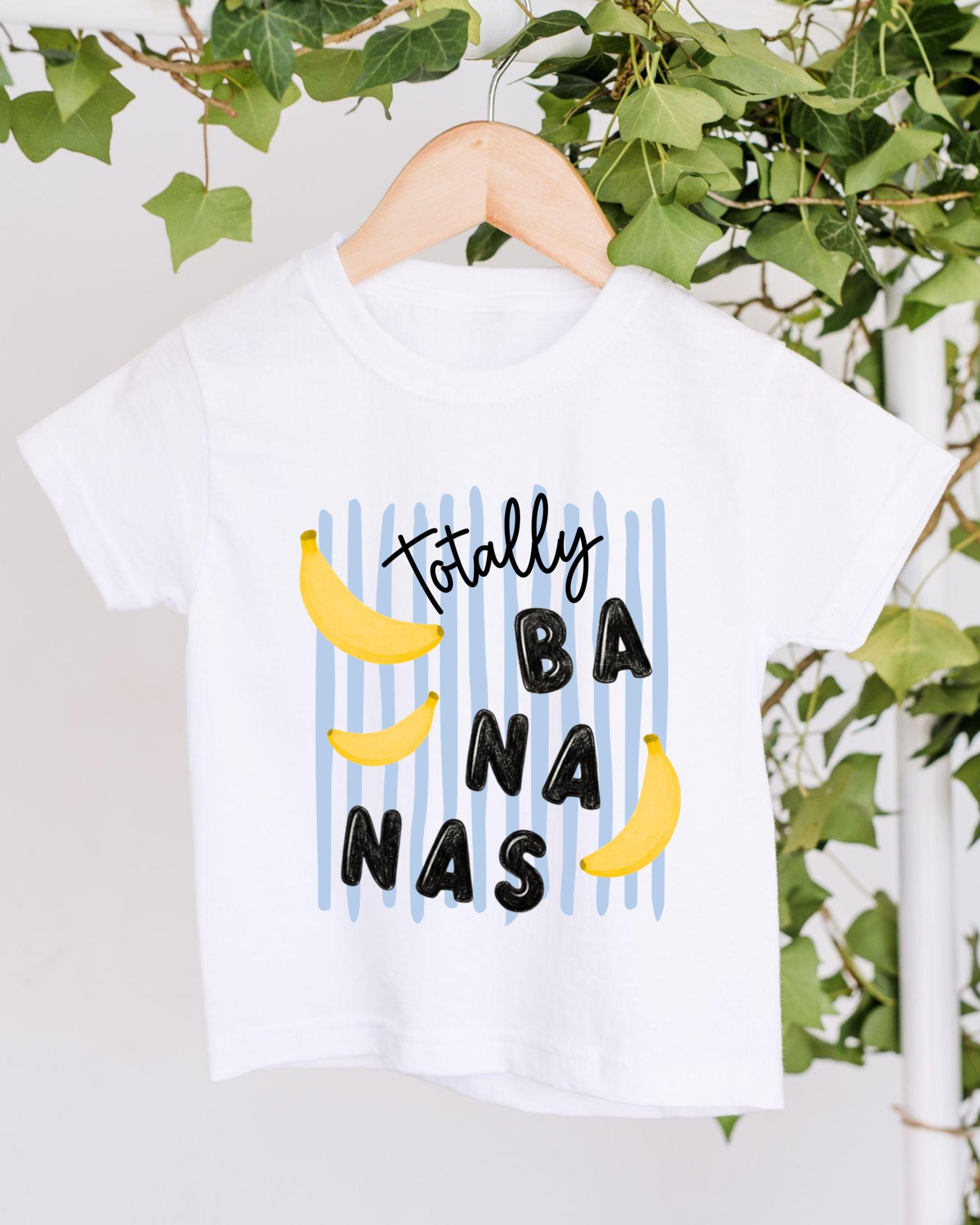A white t-shirt with a graphic design featuring bananas and the text "Totally BANANA" printed on it.
