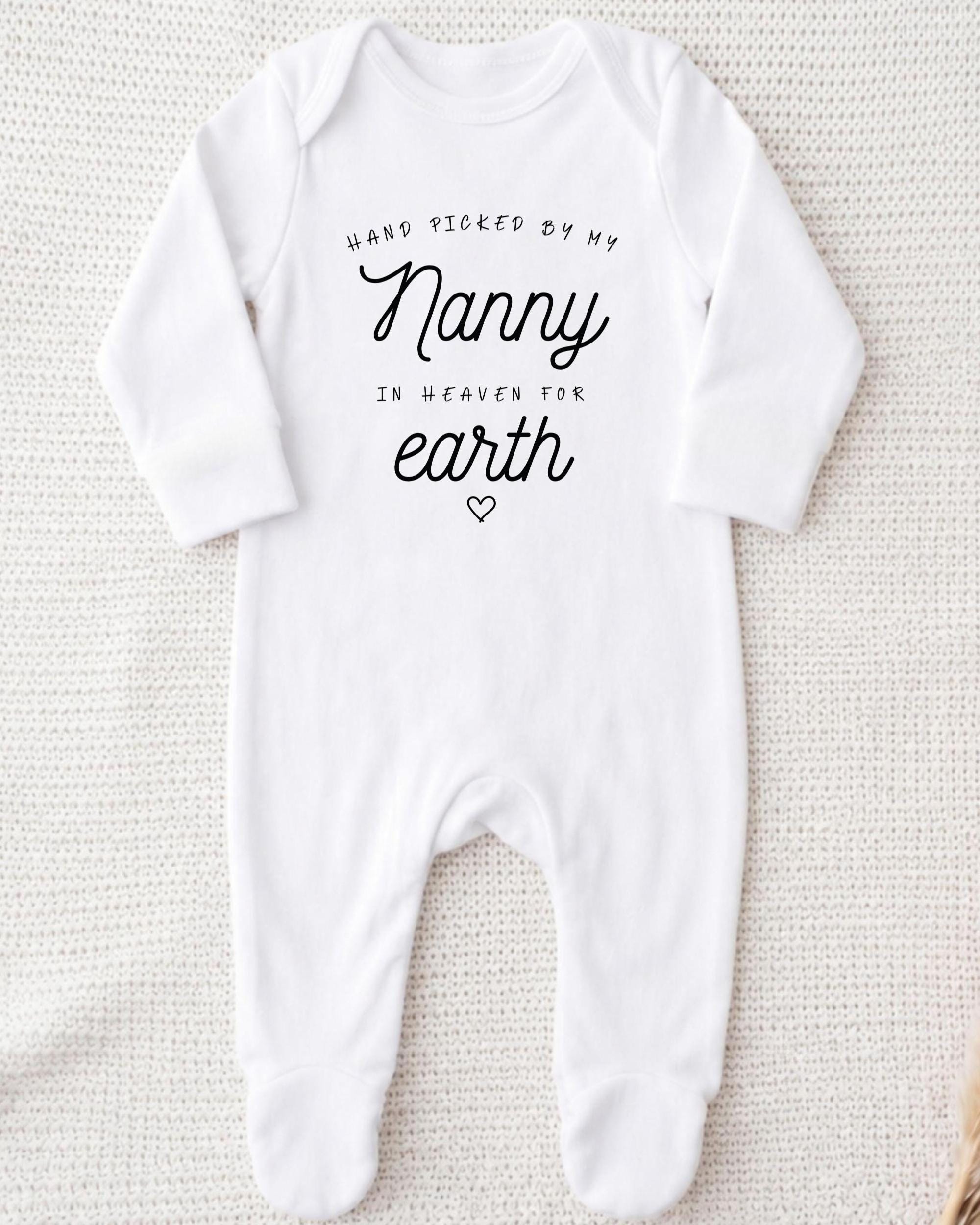 A white onesie with the text "Hand picked by my Nanny in heaven for earth" printed on it.