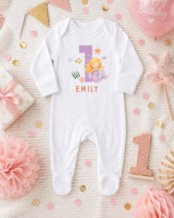 A white onesie with a mermaid design and the name "EMILY" printed on it, surrounded by pink and gold decorations, including a pink star, a pink flower, and confetti.