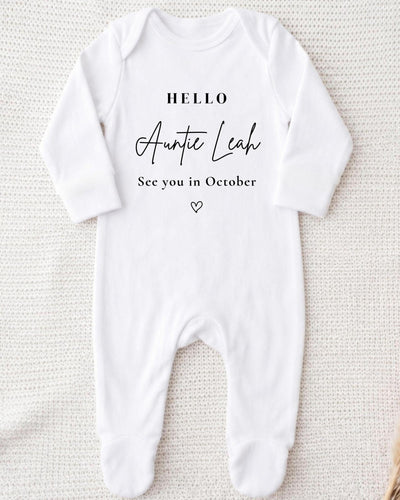 A white bodysuit with the text "Hello Auntie Leah See you in October" printed on it.