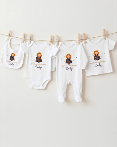 A row of four white baby clothes with a small cartoon character on them, hanging on a clothesline.