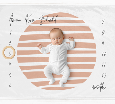 a baby is laying on a pink and white background