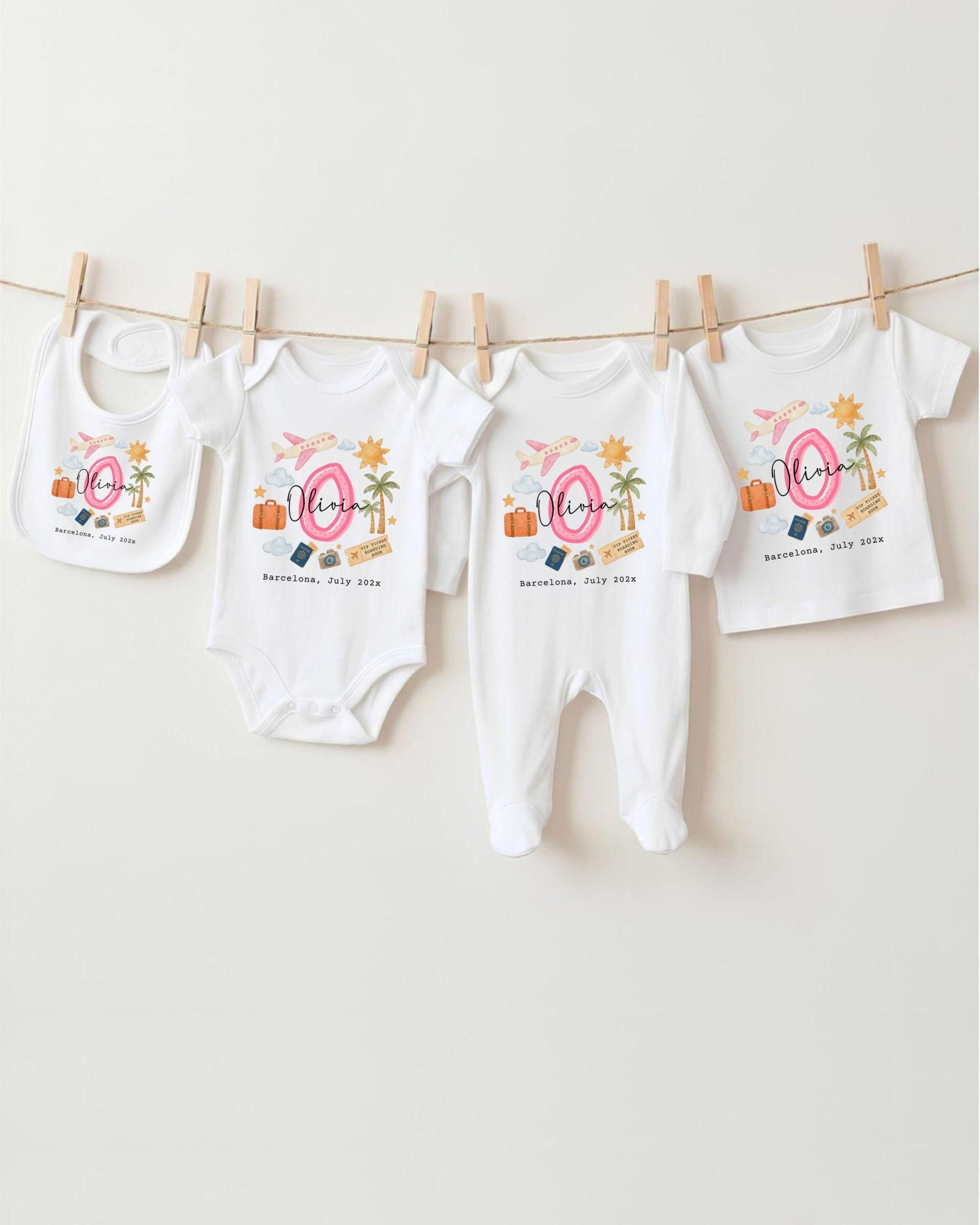 A collection of baby clothes, including onesies and bibs, hanging on a clothesline.