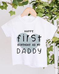 A white t-shirt with a graphic design that says "Happy first birthday as my Daddy" in black text.