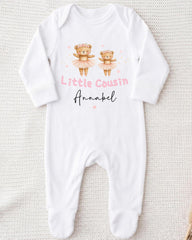 A white onesie with a design of two teddy bears in tutus and the text "Little Cousin Annabel" printed on it.