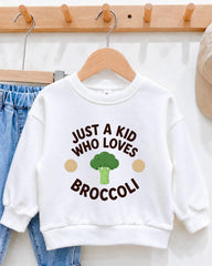 A white sweatshirt with a humorous text printed on it, hanging on a wooden hanger.