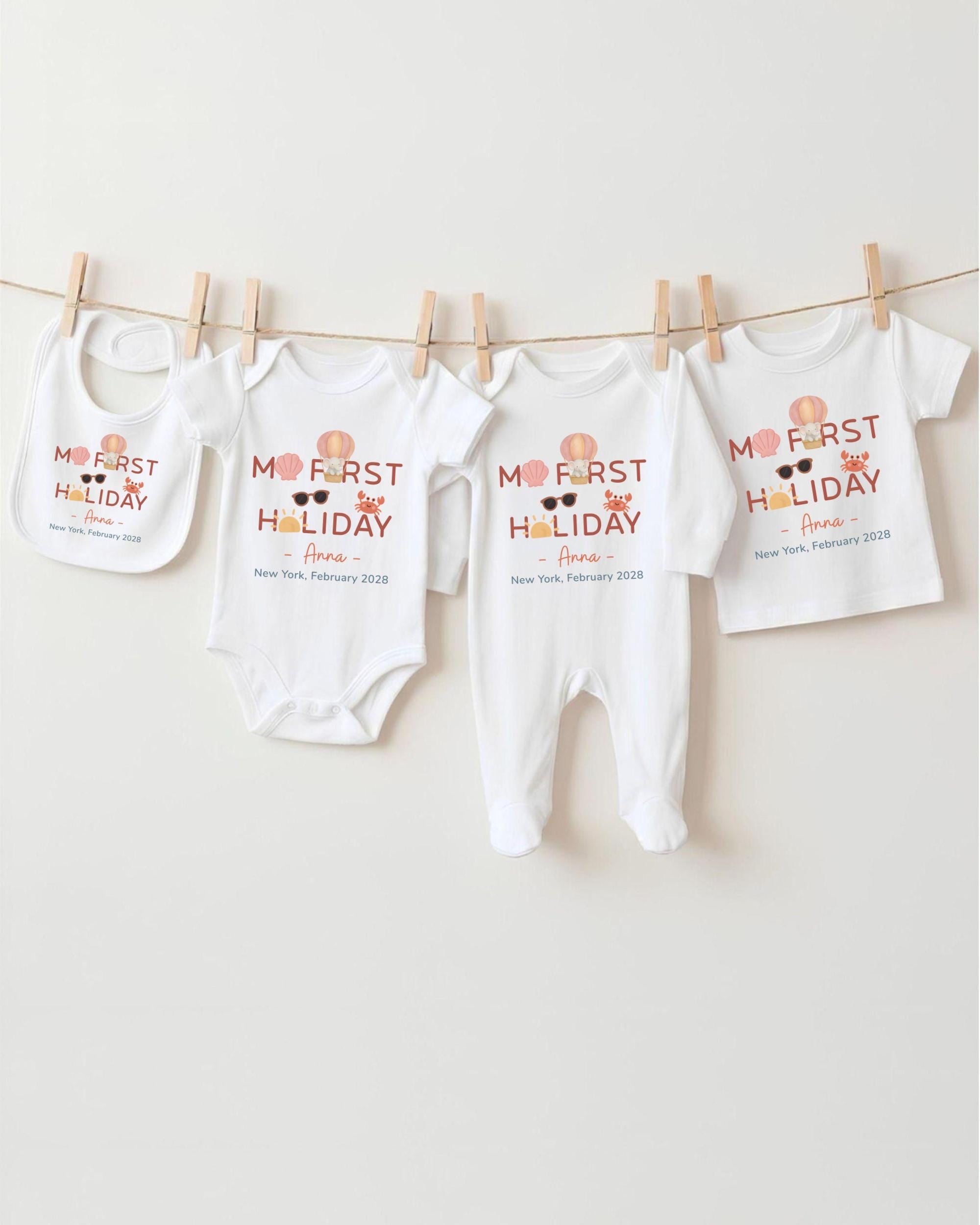 a collection of baby clothes hanging on a clothesline, with the clothes appearing to be baby onesies and bibs.