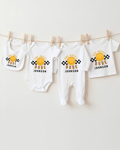 A collection of baby clothes, including bodysuits and bibs, hanging on a clothesline.