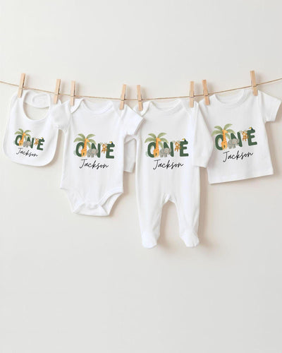 A collection of white baby clothes, including bodysuits and pajamas, hanging on a clothesline.