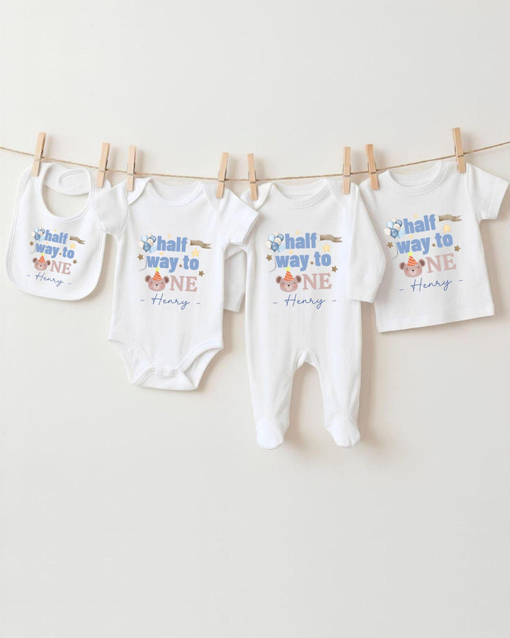A collection of baby clothes, including onesies and pants, hanging on a clothesline.