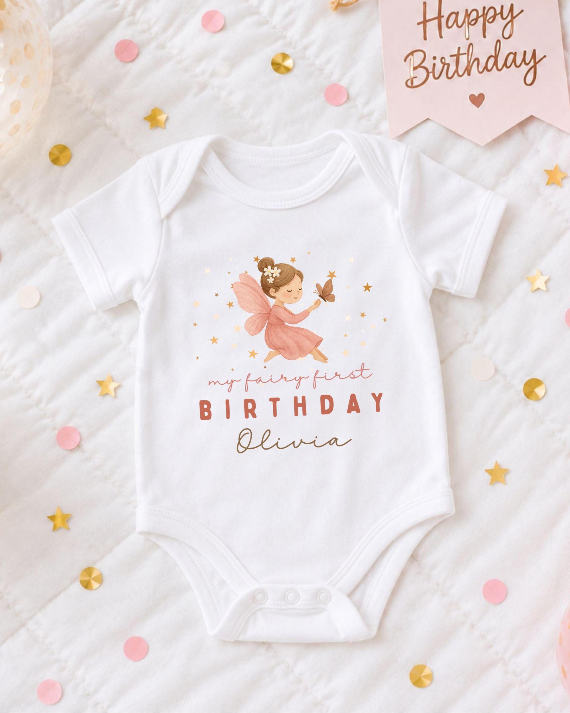 A white onesie with a fairy design and the text "My fairy first birthday Olivia" printed on it, along with confetti and a birthday banner.