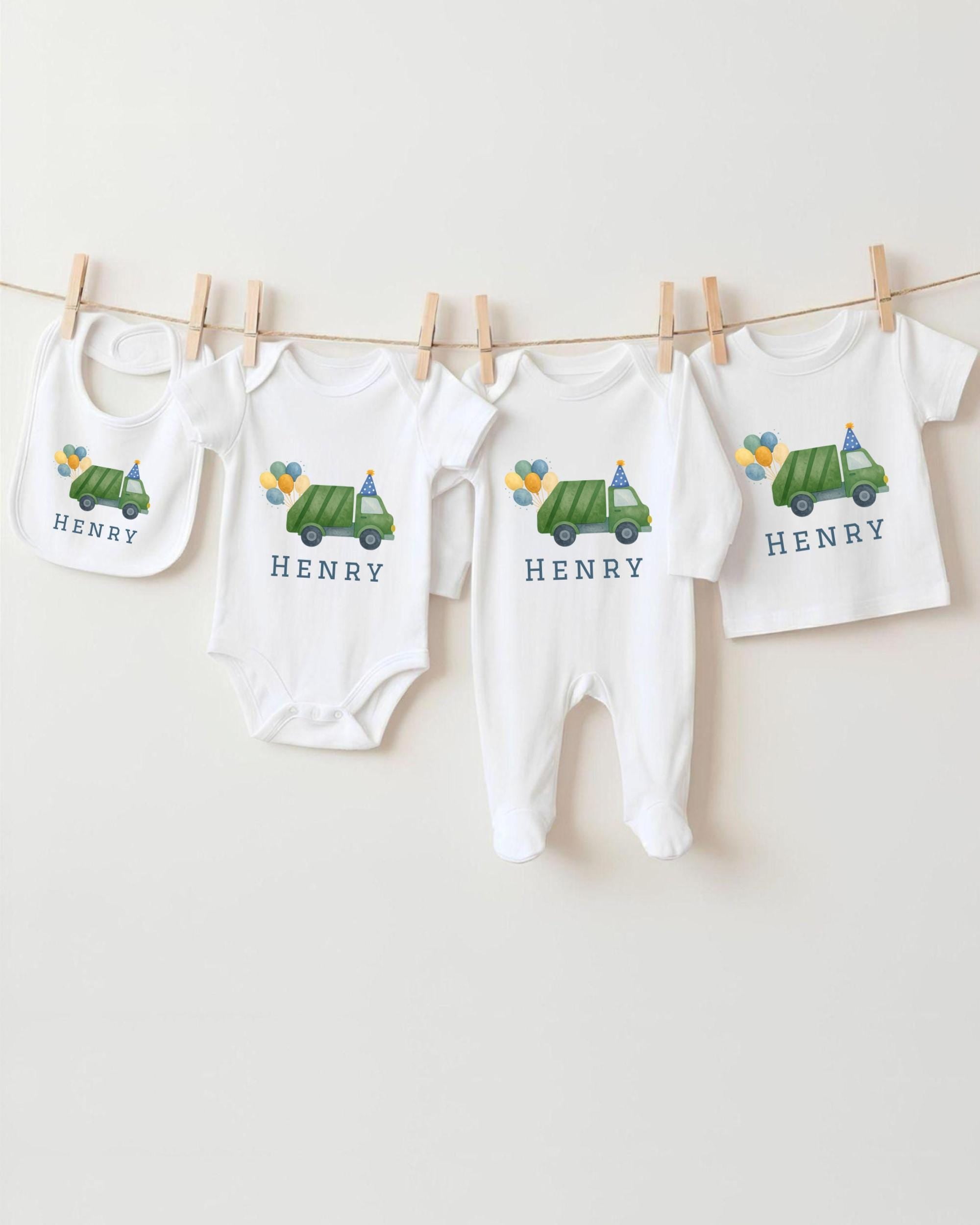 A collection of baby clothes, including onesies and bibs, are hanging on a clothesline.