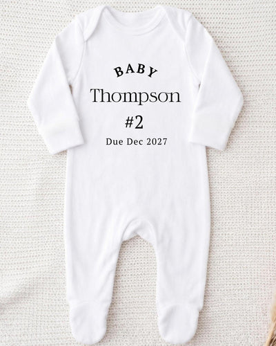 Personalised white Bib with black 'Baby Thompson #2 Due Dec 2027' lettering for a second baby pregnancy announcement.