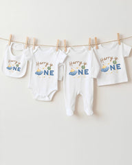 A collection of white baby clothes, including onesies and pajamas, hanging on a clothesline.