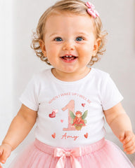 A smiling baby girl wearing a white t-shirt with a fairy graphic and the text "When I wake up I will be Amy" printed on it.