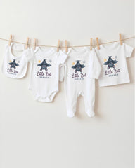 A collection of baby clothes, including onesies and bibs, hanging on a clothesline.