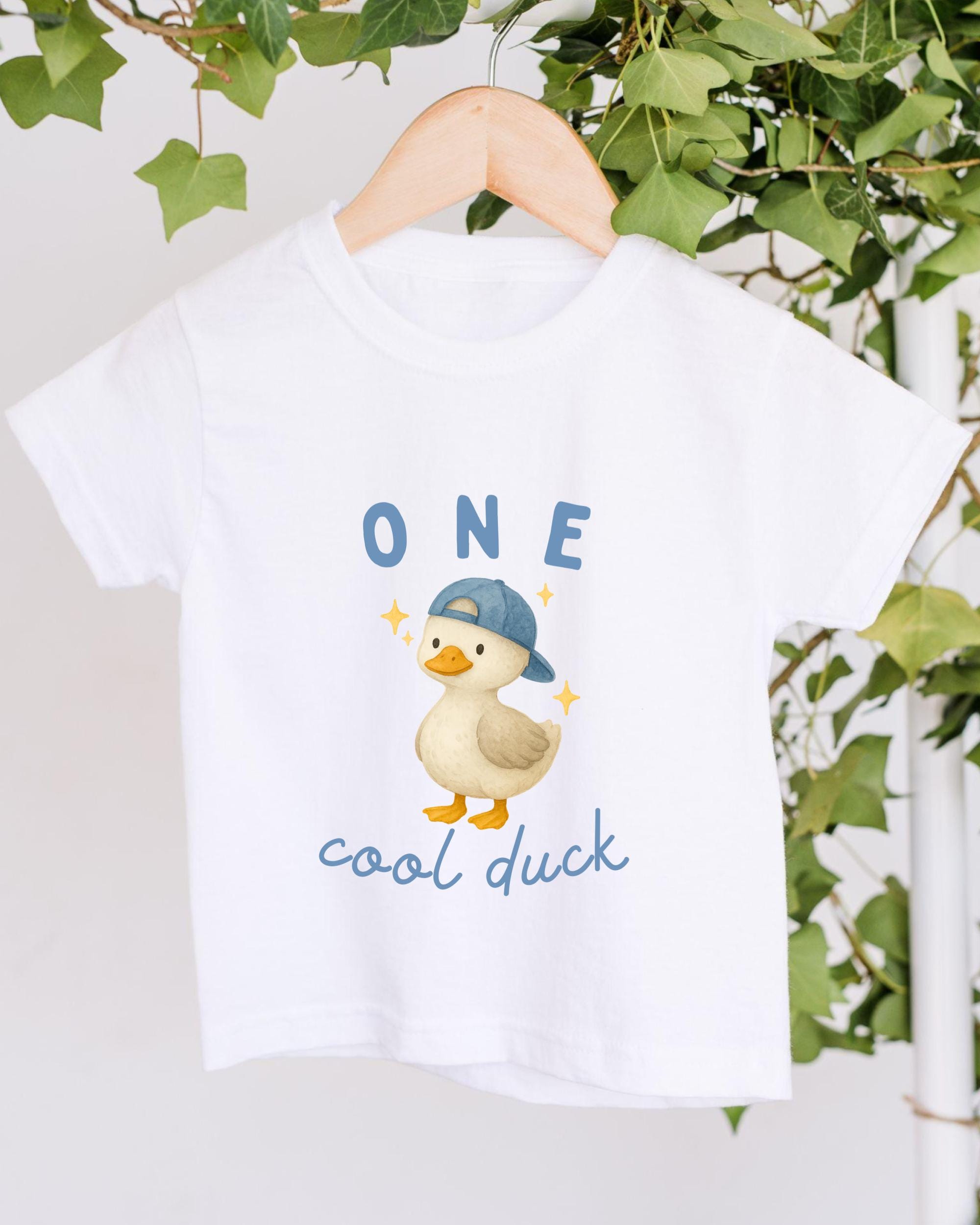 A white t-shirt with a cartoon image of a duck wearing a baseball cap and the text "ONE cool duck" printed on it.