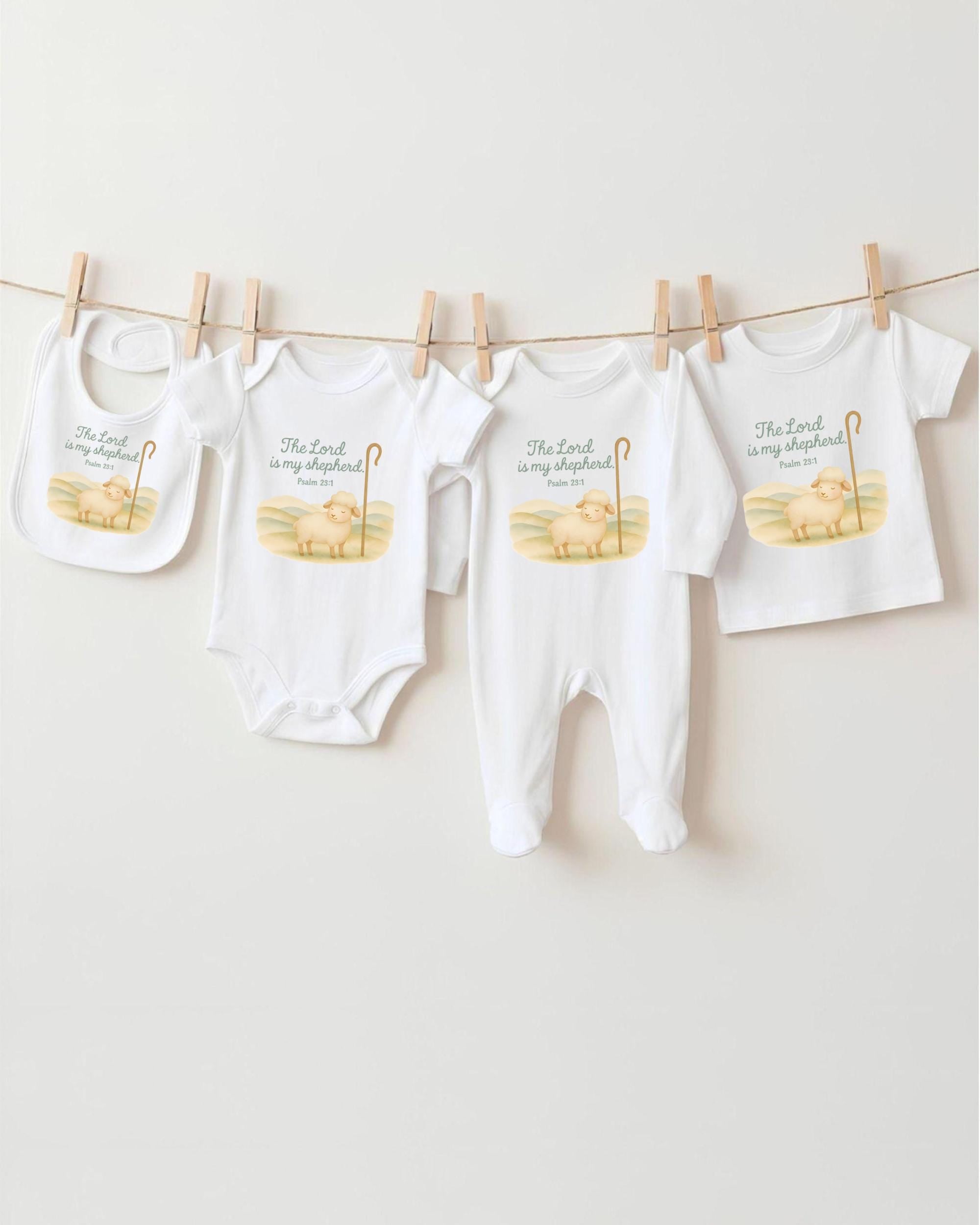 A collection of baby clothes and bibs hanging on a clothesline, featuring religious text and illustrations.