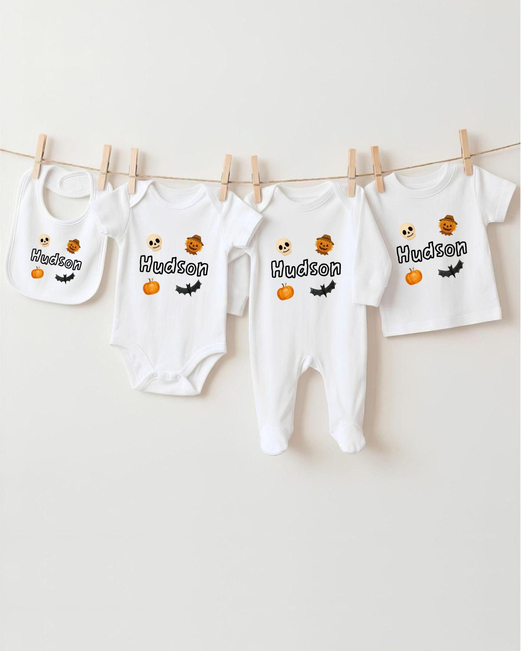 A collection of white baby clothes, including onesies and bibs, hanging on a clothesline.